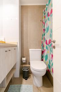a bathroom with a toilet and a shower curtain at Departamento céntrico con estacionamiento in Concepción