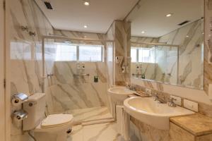a bathroom with a toilet and a sink and a shower at Hotel Transamerica Berrini in São Paulo