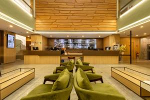 サンパウロにあるHotel Transamerica Berriniの緑の椅子とバーのあるロビー