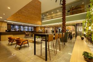a restaurant with a bar with chairs and tables at Hotel Transamerica Berrini in São Paulo