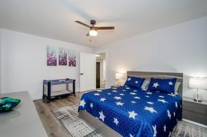 Schlafzimmer mit einem blauen Bett und einem Deckenventilator in der Unterkunft Cozy Adventure Basement - Sleeps 5 in Buford + 17 Fotos
