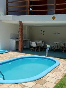 een groot blauw zwembad in een tuin met een tafel bij Vilacessivel Pousada in Porto De Galinhas