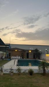 a pool in a yard with chairs and a building at Kinaara farms in Dāsna
