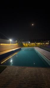 an empty swimming pool at night with lights at Kinaara farms in Dāsna