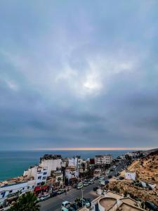 a city street with buildings and the ocean at Ami D'or Hostel in Taghazout