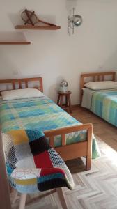 a bedroom with two beds with colorful blankets at Villa MB in Lenna +8 photos