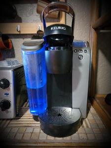 a coffee maker with a blue cup next to a blender at Beach Go-Boho Private FIFTY DOLLARS Room Coffee - Tea FREE! INSTANT BOOK in Brunswick