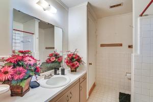 a bathroom with a sink and a mirror and flowers at Pet-Friendly Eutaw Home Near Historic Square in Eutaw +17 photos
