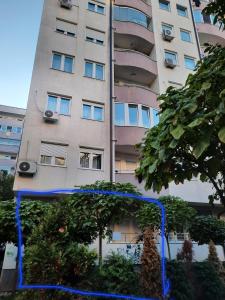 a tall building with a blue string in front of it at Appartment is located in the center of town Fushe Kosova in Kosovo Polje