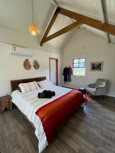 a large bedroom with a large bed and a chair at Chalé Exclusivo com Spa e Vista Mágica, Top Urubici in Urubici