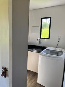 a small kitchen with a sink and a washing machine at Chalé Exclusivo com Spa e Vista Mágica, Top Urubici in Urubici +56 photos