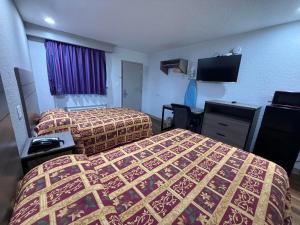 テキサスシティにあるEconomy Lodge by Hotel O Texas Cityのベッド2台と薄型テレビ付きのホテルの部屋