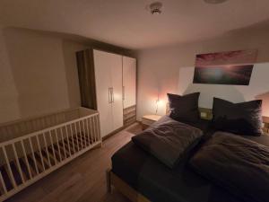 a bedroom with a bed and a white cabinet at FERIENWOHNUNG 52m2 APARTMENT in ZITTAUER STADTZENTRUM INNENSTADT INNENRING TOP LAGE - WOHNEN AUF ZEIT IN ZITTAU - 2 RAUM WOHNUNG EINKAUFSSTRASSE in Zittau