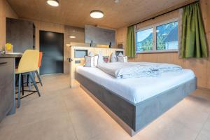a bedroom with a large bed and a kitchen at TinyHome Singer - inclusive private Sauna in Ehenbichl