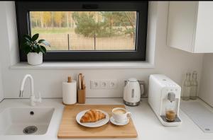 un bancone della cucina con un piatto di croissant e una macchina per il caffè di NATURA APARTAMENTY Era a Ulinia