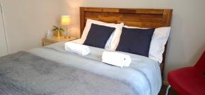 Un dormitorio con una cama grande con dos almohadas. en Modern Sunny & Comfy Rooms near Henderson, Auckland, en Auckland
