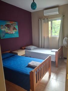 a bedroom with two beds and a window at Casa palmera in San Juan del Sur +31 photos
