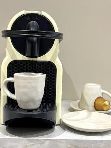 eine Kaffeemaschine mit einer Tasse auf dem Tisch in der Unterkunft Le Fleury in Fontenay-le-Fleury