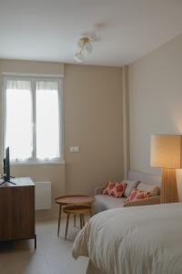 ein Schlafzimmer mit einem Bett, einer Couch und einem Tisch in der Unterkunft Le Fleury in Fontenay-le-Fleury