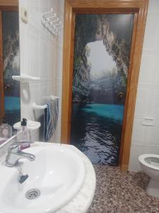 a bathroom with a sink and a door with a window at turismo rural la solana in Murcia