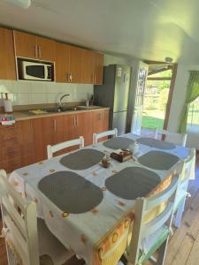 a kitchen with a table with chairs and a microwave at Cabana El Sauce in San Patricio