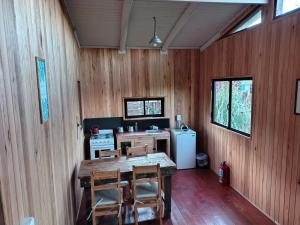 a room with a table and chairs and a refrigerator at Cabañas Entre Rios in Concepción del Uruguay