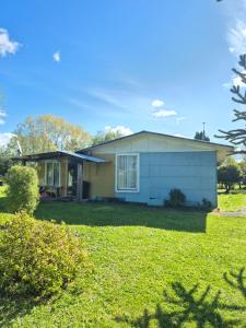 a house with a green lawn in front of it at Cabana El Sauce in San Patricio