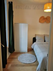a bedroom with a white cabinet next to a bed at 34m2 cosy proche métro in Ivry-sur-Seine