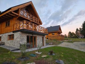 a log house with a balcony on top of it at Blisko natury - chatki z sauną w Zawoi in Zawoja
