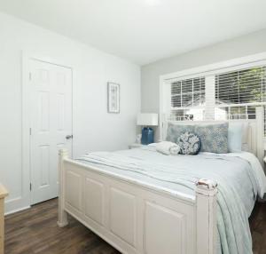 1 dormitorio blanco con 1 cama grande y ventana en Encanto del sur, en Charleston
