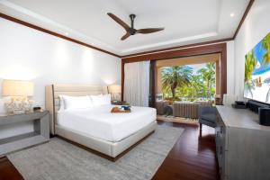 a bedroom with a white bed and a television at Montage Kapalua Bay 2 Free Rental Cars KBM Resorts Beautiful Villa At Montage Kapalua Bay 2 Units 6 Bedrooms ML-1231 in Honokahua +49 photos