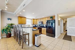 a kitchen with wooden cabinets and a black refrigerator at Emerson Towers 504 in Ocean City