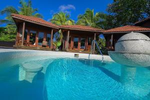 a swimming pool with a fountain in front of a house at Marbucks Bed & Breakfast in San Pedro