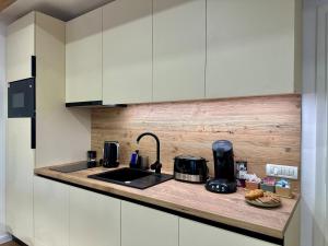 a kitchen with white cabinets and a counter top at Central House - Modern Apartment in Zărneşti