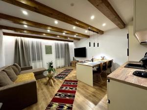 a kitchen and living room with a couch and a table at Central House - Modern Apartment in Zărneşti