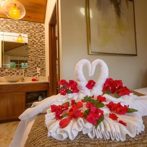 Un cisne hecho de flores sobre una cama en un baño. en Marbucks Bed & Breakfast, en San Pedro 15 fotos más