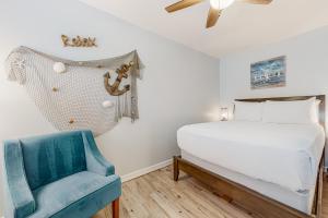 a bedroom with a bed and a blue chair at Leeward Cove A8 in Padre Island +21 photos