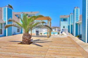 a palm tree on a boardwalk in front of condos at Leeward Cove A8 in Padre Island