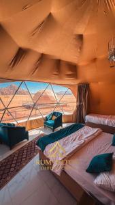 un grande letto in una tenda con una grande finestra di RUM HiLTON lUXURY CAMP a Wadi Rum