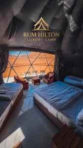 una stanza con due letti e un cartello con la scritta "run religion luxury camp" di RUM HiLTON lUXURY CAMP a Wadi Rum