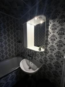 ein Badezimmer mit Waschbecken, Spiegel und Badewanne in der Unterkunft Apartmán Šurany in Šurany + 16 Fotos
