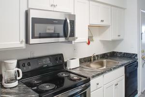 a kitchen with a black stove and a microwave at Assateague House 511 in Ocean City