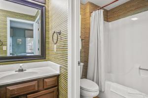 a bathroom with a sink and a toilet and a mirror at Tidewater 1911 in The Old Home Place +23 photos
