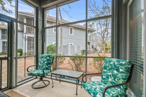 a screened porch with two chairs and a table at Tidewater 1911 in The Old Home Place
