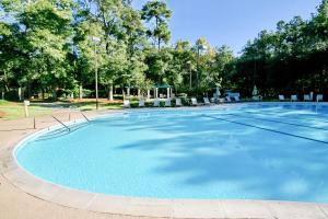 a large blue pool with chairs and trees at Tidewater 1911 in The Old Home Place