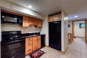 a kitchen with black appliances and wooden cabinets at Moose Lodge Unit B in North Bethel