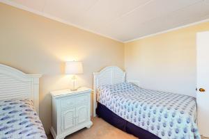 a bedroom with two beds and a lamp on a night stand at Ocean Place 401 in Ocean City +11 photos