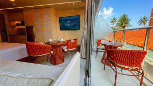 a balcony with a bed and a table and chairs at Setai Aquamaris Luxo - By Almare in Tambaú