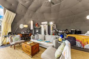 a living room with a bed and a room with a couch at The Dome in Cloptins Crossing