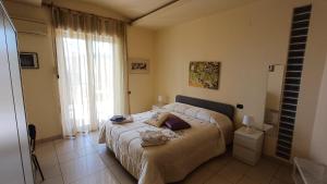 バッティパーリアにあるA casa di Geriのベッドと大きな窓のある寝室